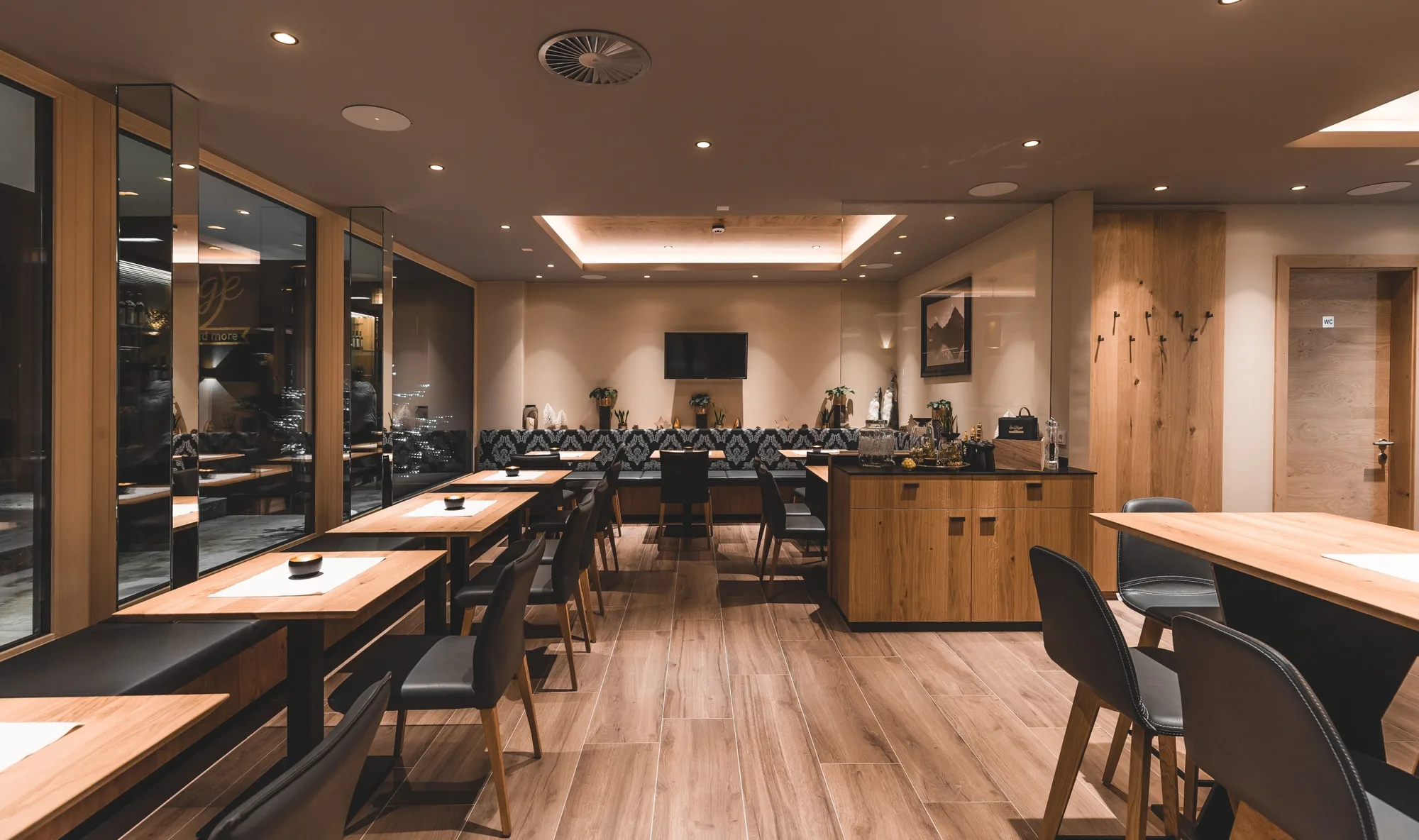 Sitzbereich der Mathon Lounge mit Holztischen, Lederstühlen und Panoramafenstern
